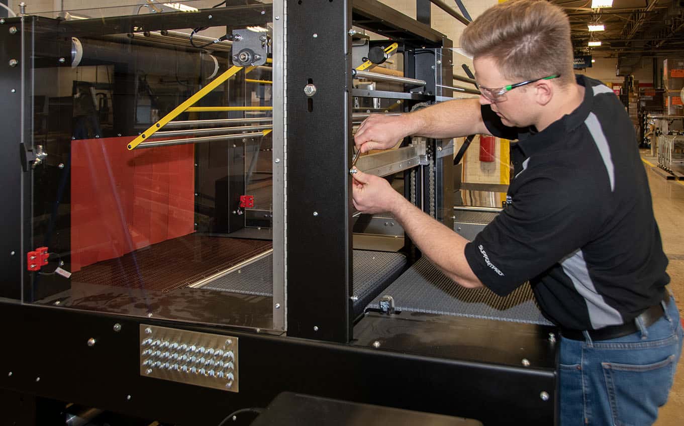 Person using wrench on machine